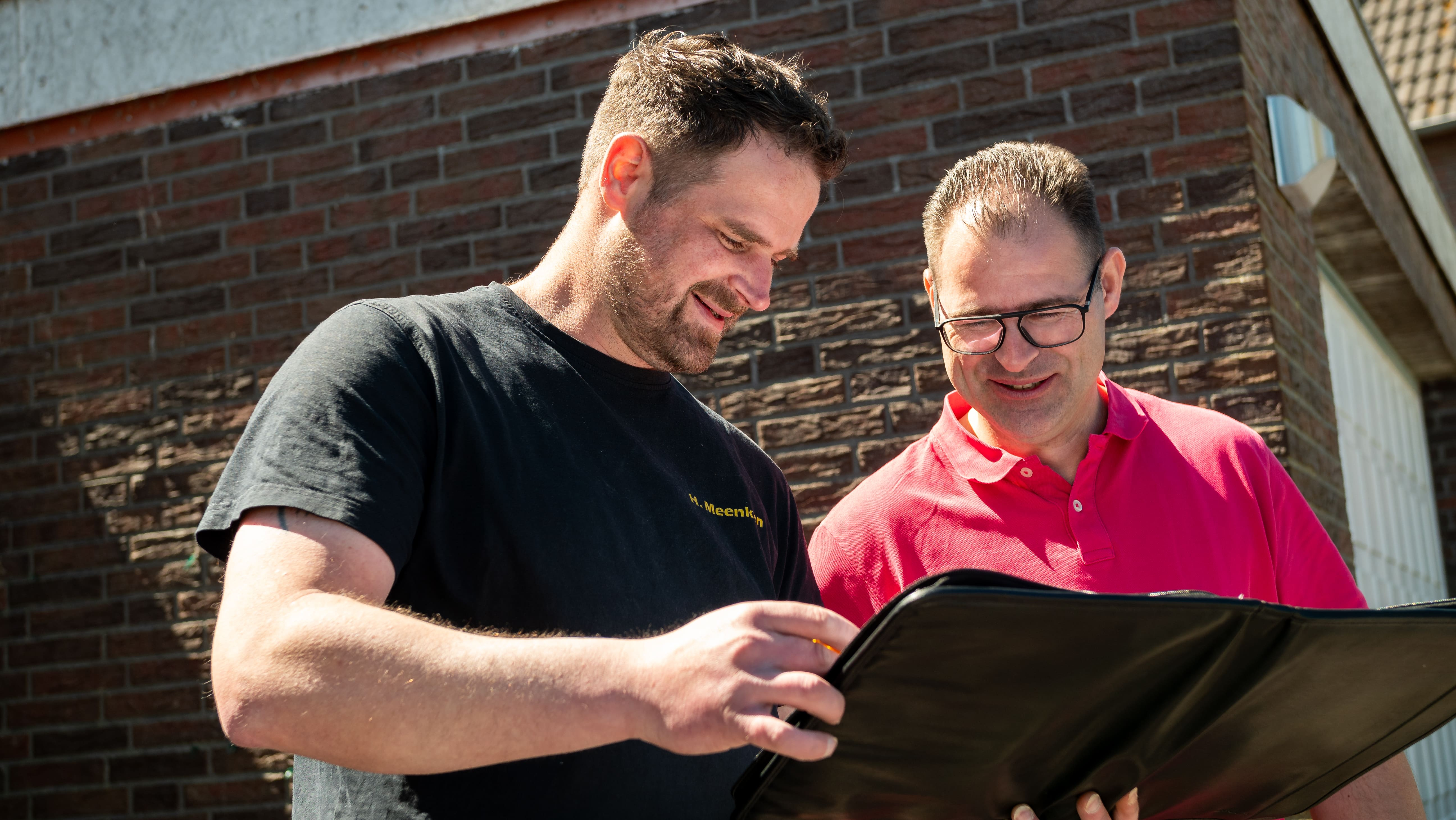 Ankunft beim Kunden vor dem Haus - Mitarbeiter und Kunde besprechen die Details